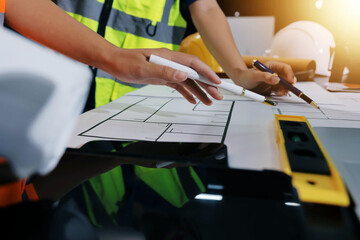 Closeup of team of industrial engineers meeting analyze machinery blueprints consult project on...