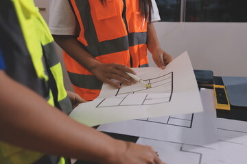 Closeup of team of industrial engineers meeting analyze machinery blueprints consult project on...