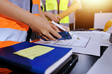Closeup of team of industrial engineers meeting analyze machinery blueprints consult project on...