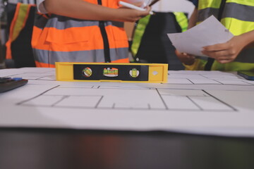Closeup of team of industrial engineers meeting analyze machinery blueprints consult project on...