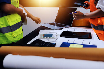 Closeup of team of industrial engineers meeting analyze machinery blueprints consult project on...