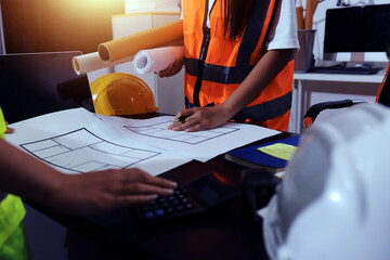 Closeup of team of industrial engineers meeting analyze machinery blueprints consult project on...