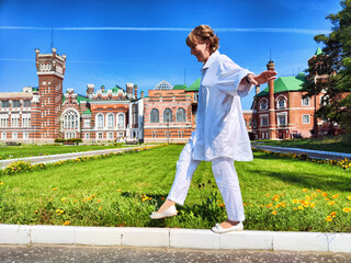 Mature woman enjoys a joyful stroll through a picturesque park in Hong Kong during a sunny travel...