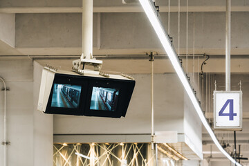 Surveillance monitors showing train arrival at platform in urban transit station