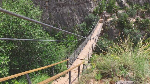 Footbridge, rope suspension bridge over the river Turia. Puente Colgante Chulilla, Spain.