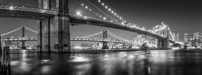 Evening panoramic Black and White East River view of the Brooklyn Bridge and Manhattan Bridge....