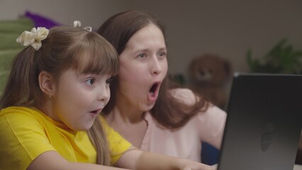 child schoolboy mother sitting computer joyfully surprised victory online digital competitions....
