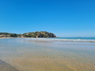 Sunny day at Geribá Beach, Búzios, Brazil. Golden sand, crystal clear water, strong waves, vibrant blue sky. Tropical paradise, serene landscape, summer vibe during Brazilian winter.