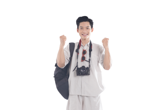 Young Traveler's Exuberant Joy: A smiling Asian traveler, backpack slung over his shoulder and camera around his neck, throws his fists in the air in uncontainable excitement.