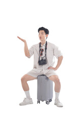Traveler's Journey: A young man, ready for adventure, sits atop a suitcase, gesturing towards a destination unknown. The image captures the excitement and anticipation of travel.