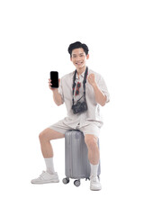 Traveler's Triumph: An asian man with camera hold phone and sit on suitcase in white background.