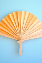Elegant wooden folding fan displayed as a fashion accessory against a pastel backdrop, minimal high-end editorial style
