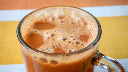 Frothy Malaysian Teh Tarik on a Striped Table