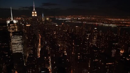 Nighttime aerial view showcases New York City's dazzling skyline illumination, creating a majestic - Powered by Adobe