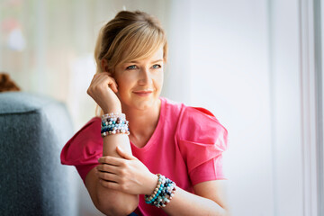 Portrait of a blond haired woman relaxing in an armchair at home