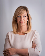 Blond haired woman standing against isolated background