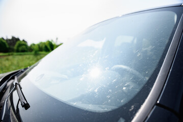 Smeared and dirty front windshield of a vehicle after hitting bugs.