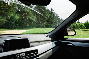 Smeared and dirty front windshield of a vehicle after hitting bugs.