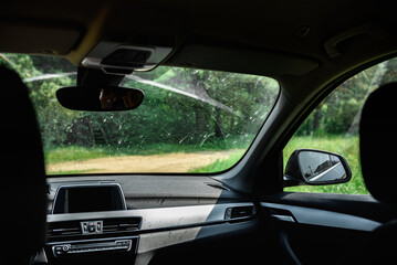 Smeared and dirty front windshield of a vehicle after hitting bugs.