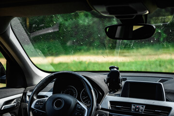 Smeared and dirty front windshield of a vehicle after hitting bugs.