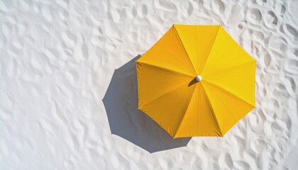  Top view of a bright yellow beach umbrella casting a soft circular