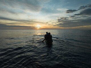 Aerial view of traditional Asian fishing boats in the middle of the ocean. Traditional Asian fishermen heading out to sea at dusk