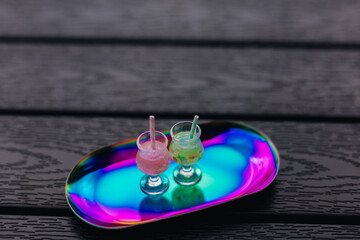 Two refreshing cool and funky cocktails with straws on a colorful, reflective tray. Summer...
