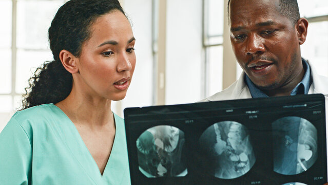 Medical Professionals Discussing Patient's X-Ray Results in a Bright Hospital Setting