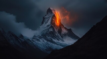 A snow covered mountain ridge with a blazing orange glow