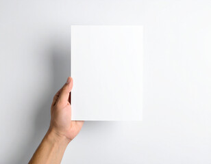Obraz premium Hand holding a white paper mock up isolated on white background
