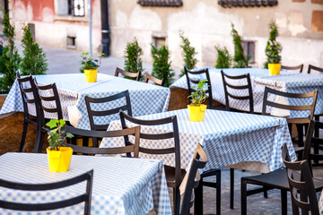 Outdoor empty Cafe Seating. Chairs and tables. Old tourist town in summer street bar. Tablecloth