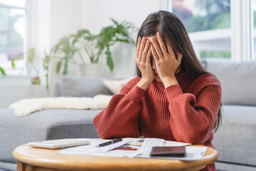 Women calculating her income and feeling anxious about paying the due for her debts.