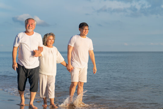 Family On Summer Beach Vacation, Father and mather running with son, Concept for 
caring for the elderly, Caregiving to older persons and relations of the family to support elderly state