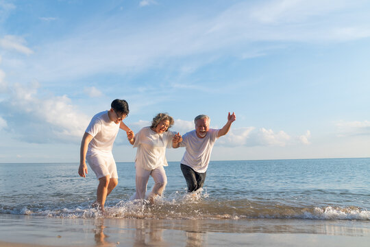 Family On Summer Beach Vacation, Father and mather running with son, Concept for 
caring for the elderly, Caregiving to older persons and relations of the family to support elderly state - Powered by Adobe