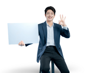 A happy Asian businessman holds a blank sign and makes an "OK" gesture, indicating a perfect deal, result, or excellent service.
