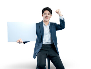 A successful young businessman holds a blank sign and cheers with a fist pump, celebrating a winning announcement or promotion.
