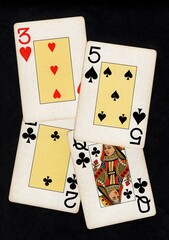 A montage of four vintage playing cards isolated on a black background.