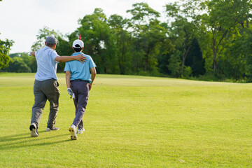 Asian man and elderly father are enjoy playing golf together with a good time.