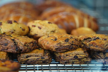 Close-Up of Delicious Chocolate Chip Scones and Raisin Cookies in a Bakery Display