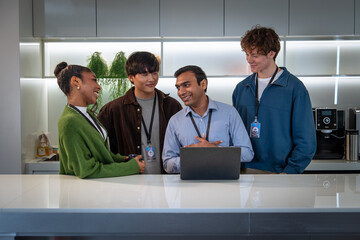 A diverse group of professionals engage in conversation around a modern kitchen island, showcasing teamwork and collaboration in a casual setting.