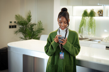 Happy black woman, phone and communication Online at office, African female person or employee enjoying online browsing or chat on mobile smartphone app at workplace.
