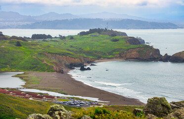 Panoramic view of Rodeo Beach, Fort Cronkhite, and lush hills of Marin Headlands near Highway 1,...