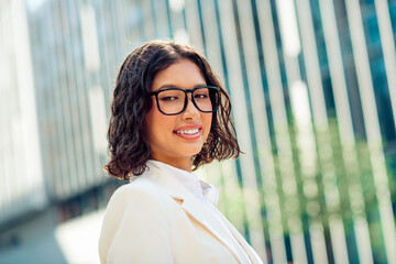 Successful Young Businesswoman Outdoors in Urban Environment with Modern Office Building Background...