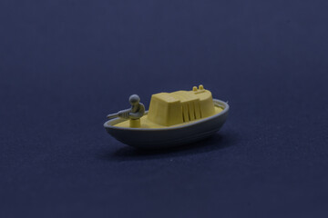 a small toy boat equipped with soldiers holding weapons on the front deck.