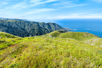 Sweeping ocean and mountain views from the Soberanes Canyon Trailhead in Garrapata State Park, along California scenic Highway 1, on a clear spring day surrounded by fresh green hills