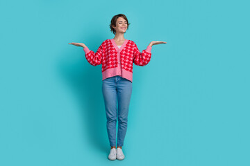 Full size photo of pretty young girl compare hold look empty space wear trendy red outfit isolated...