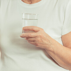 Elderly senior woman with glass of water. Healthy lifestyle and hydration in old age