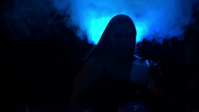 Vampire woman caresses a cup that spins expelling mist in the mysterious formulation of the smoke she kisses the mist  that is drawn a vampire look down camera