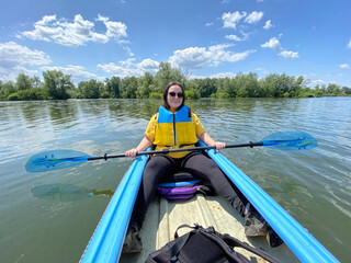 Woman Kayaking on a Calm River. Peaceful Outdoor Adventure.