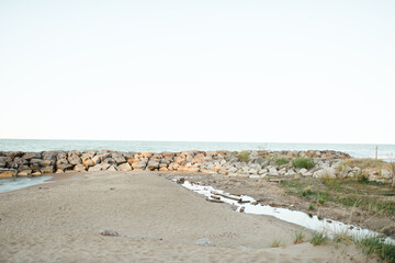 Rock wall and stream meet sandy shore at Rosewood Beach, Illinois